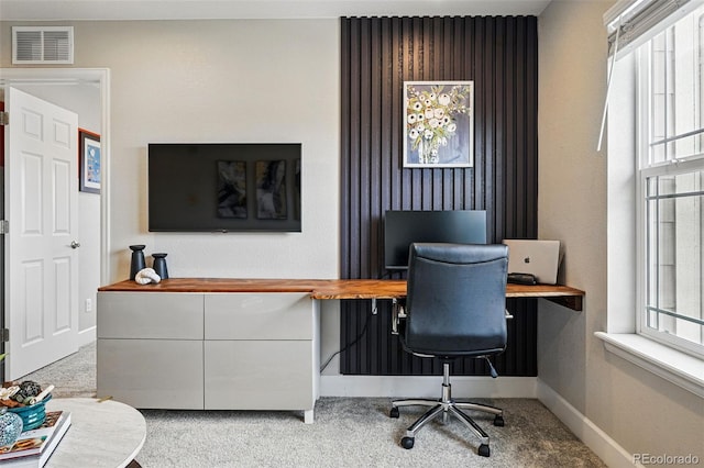 carpeted office featuring a wealth of natural light, visible vents, and baseboards