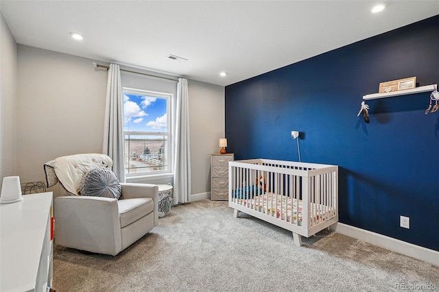 carpeted bedroom featuring baseboards, visible vents, recessed lighting, and a nursery area