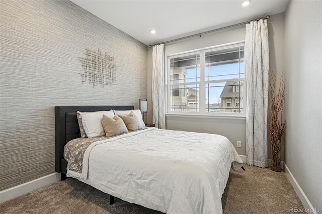 bedroom featuring carpet flooring, an accent wall, baseboards, wallpapered walls, and recessed lighting
