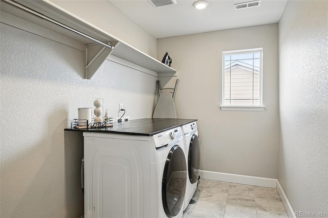 washroom with baseboards, visible vents, laundry area, and washer and clothes dryer