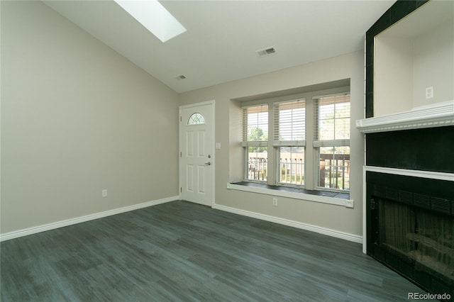 foyer featuring a fireplace, visible vents, baseboards, dark wood-style floors, and lofted ceiling with skylight