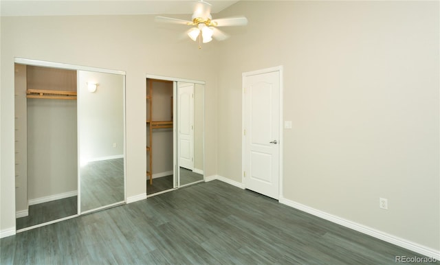 unfurnished bedroom featuring baseboards, dark wood finished floors, ceiling fan, vaulted ceiling, and two closets