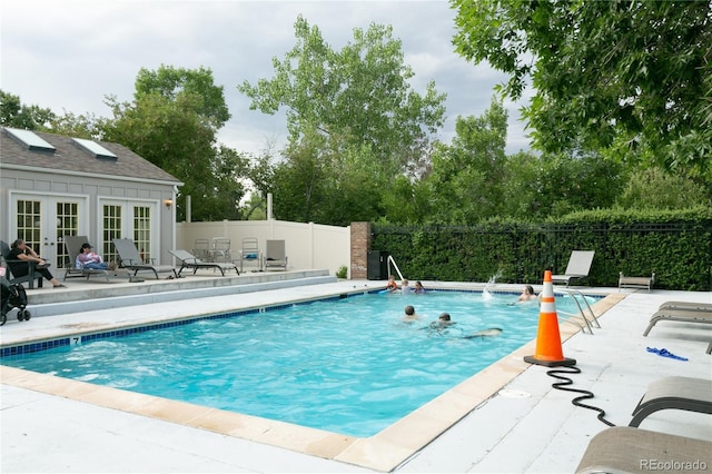 view of swimming pool with a fenced in pool, fence, a patio, and french doors