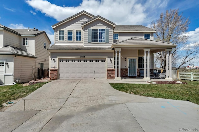 view of front facade featuring fence, a front lawn, concrete driveway, an attached garage, and brick siding