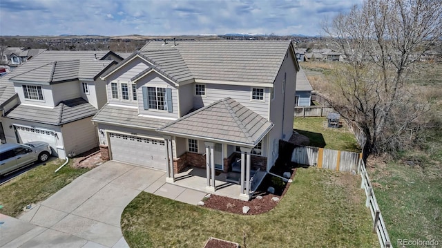 view of front facade with a front yard, an attached garage, concrete driveway, and fence
