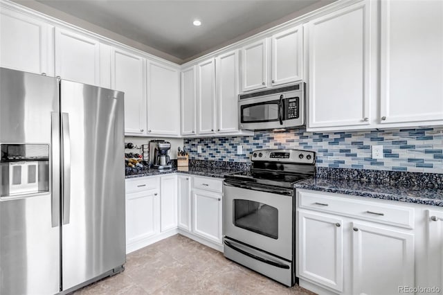 kitchen featuring stainless steel appliances, dark stone countertops, and white cabinetry