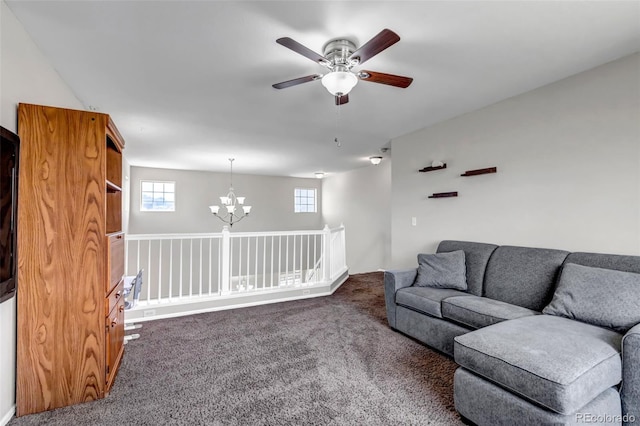 living area with dark carpet and ceiling fan with notable chandelier