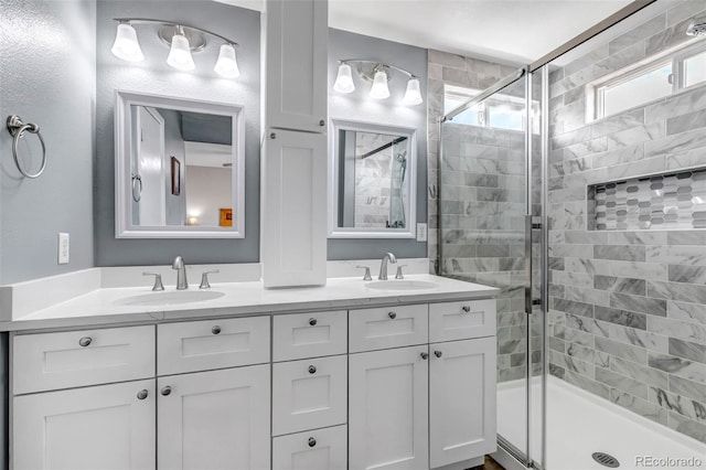 full bath with double vanity, a shower stall, and a sink