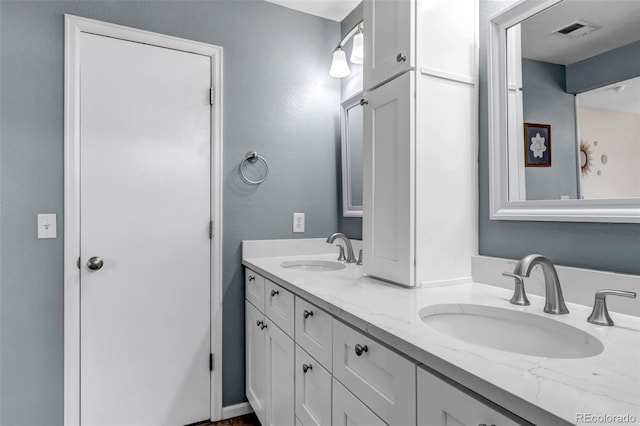 bathroom featuring a sink, visible vents, and double vanity