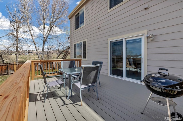 deck featuring area for grilling, outdoor dining area, and fence
