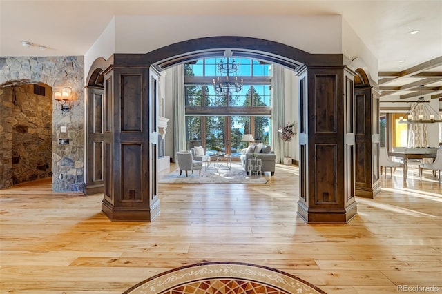 entryway featuring beamed ceiling, light hardwood / wood-style floors, and an inviting chandelier