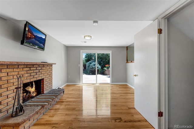 4660 E Briarwood Pl, Centennial, CO 80122 - unfurnished living room with light wood-style flooring and a brick fireplace