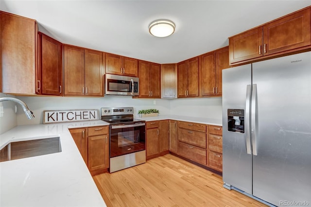 4660 E Briarwood Pl, Centennial, CO 80122 - kitchen with stainless steel appliances, light countertops, light wood-type flooring, and brown cabinetry