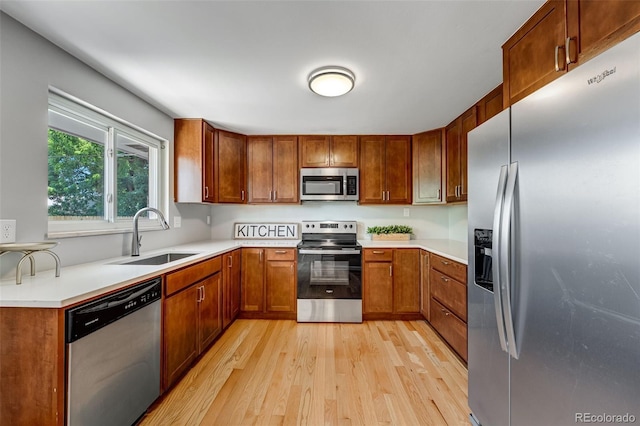 4660 E Briarwood Pl, Centennial, CO 80122 - kitchen with appliances with stainless steel finishes, light wood finished floors, light countertops, and brown cabinetry