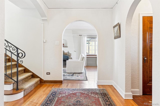 foyer entrance featuring stairs, baseboards, and wood finished floors