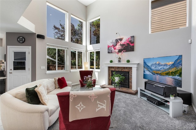 carpeted living area featuring a fireplace and a high ceiling