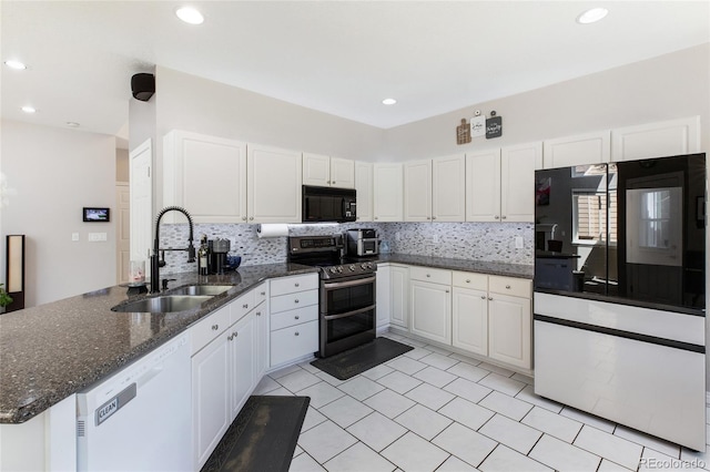 kitchen featuring black microwave, a sink, white cabinets, double oven range, and dishwasher