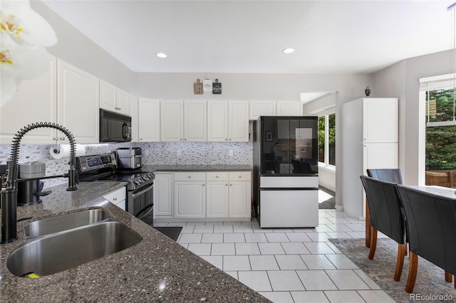 kitchen featuring black microwave, smart refrigerator, white cabinetry, and double oven range