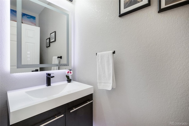 bathroom featuring a textured wall and vanity