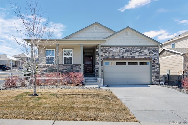 view of front of property with a porch, an attached garage, concrete driveway, a front lawn, and stone siding