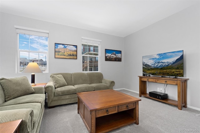 living area featuring baseboards and light colored carpet