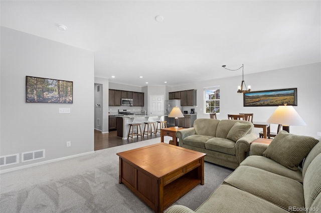 living room with visible vents, a notable chandelier, recessed lighting, carpet flooring, and baseboards