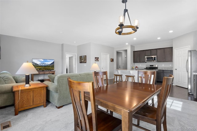 dining space featuring an inviting chandelier, recessed lighting, light colored carpet, and visible vents