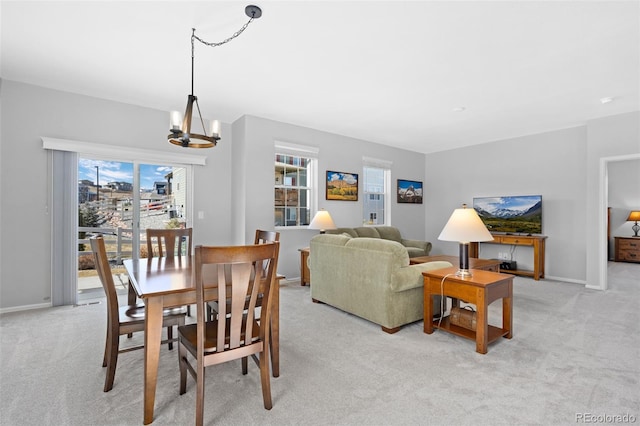 dining room with an inviting chandelier, baseboards, and light carpet