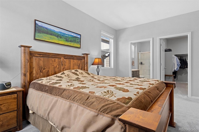 bedroom featuring baseboards, carpet floors, a spacious closet, a closet, and connected bathroom