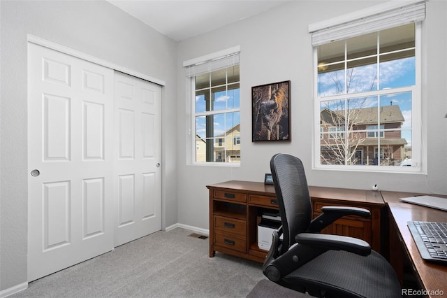 carpeted office space featuring visible vents and baseboards