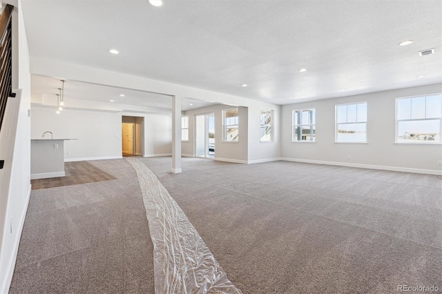 interior space featuring carpet floors and a textured ceiling