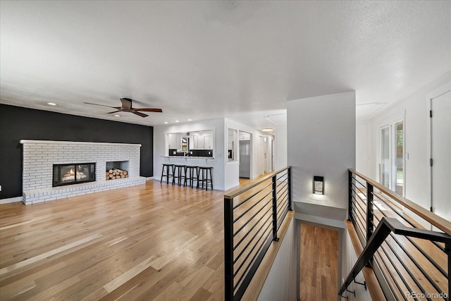 interior space with recessed lighting, light wood finished floors, a fireplace, and ceiling fan
