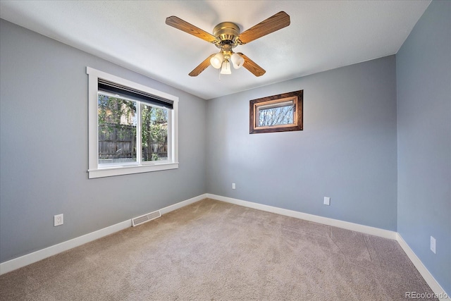 empty room featuring visible vents, baseboards, a ceiling fan, and carpet floors