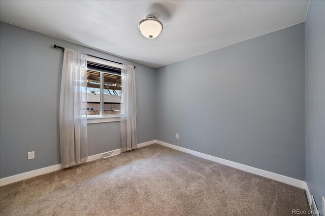 carpeted empty room with baseboards