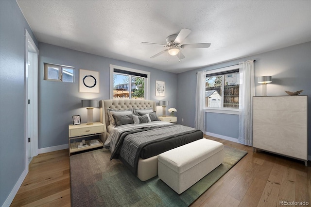 bedroom featuring baseboards, multiple windows, and hardwood / wood-style flooring