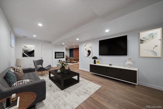 living area featuring recessed lighting, baseboards, and wood finished floors