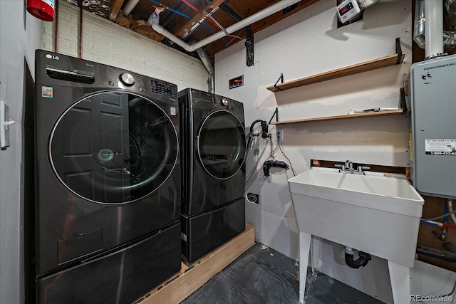 laundry room with a sink, washing machine and clothes dryer, and laundry area