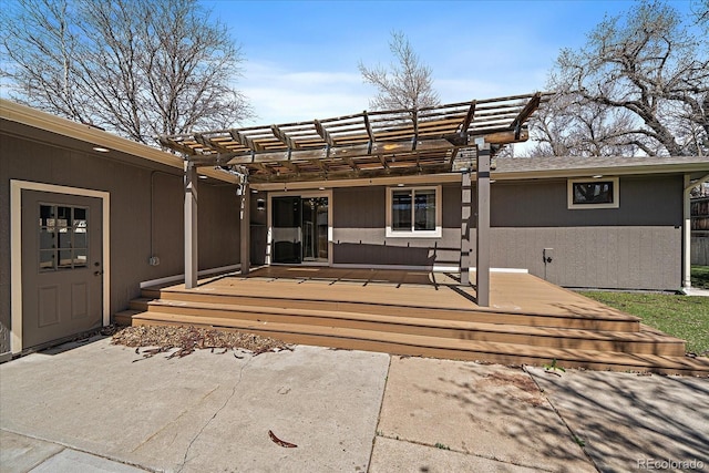rear view of property featuring a pergola and a wooden deck