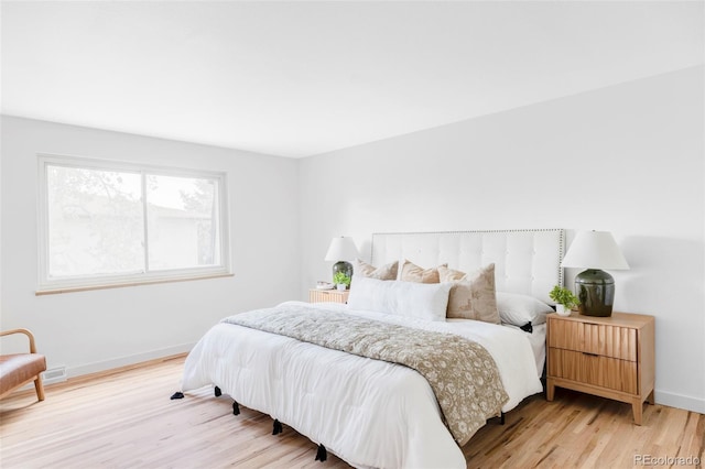 bedroom with light wood-style floors and baseboards