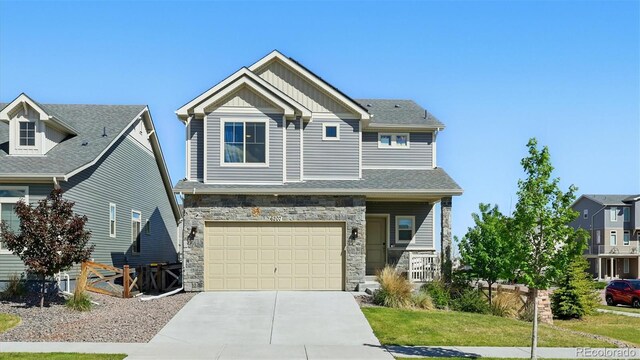 6207 Kildare Dr, Colorado Springs, CO 80927 - craftsman-style house featuring stone siding, board and batten siding, driveway, and an attached garage