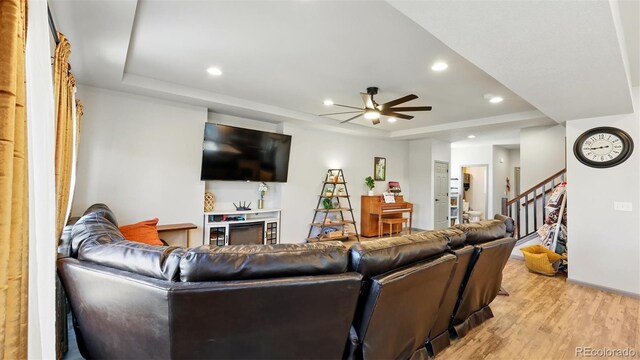 6207 Kildare Dr, Colorado Springs, CO 80927 - living area featuring a tray ceiling, light wood-style flooring, recessed lighting, ceiling fan, and stairway