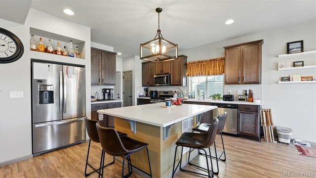 6207 Kildare Dr, Colorado Springs, CO 80927 - kitchen featuring stainless steel appliances, a kitchen bar, decorative backsplash, light countertops, and recessed lighting