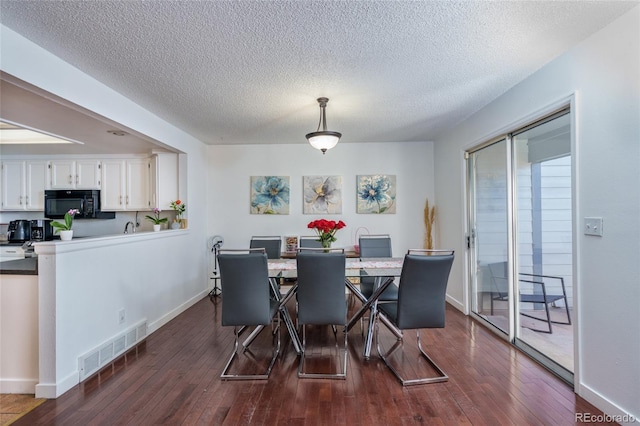 dining room with dark wood-style floors, visible vents, and baseboards