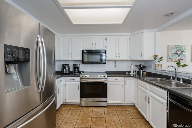 kitchen featuring black appliances, dark countertops, a sink, and white cabinetry