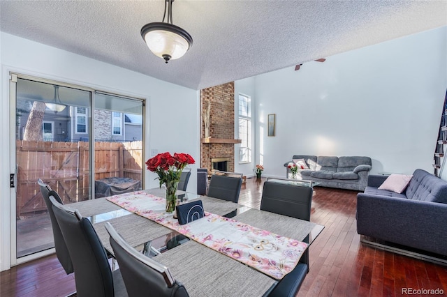 dining area featuring hardwood / wood-style flooring, a fireplace, and a wealth of natural light