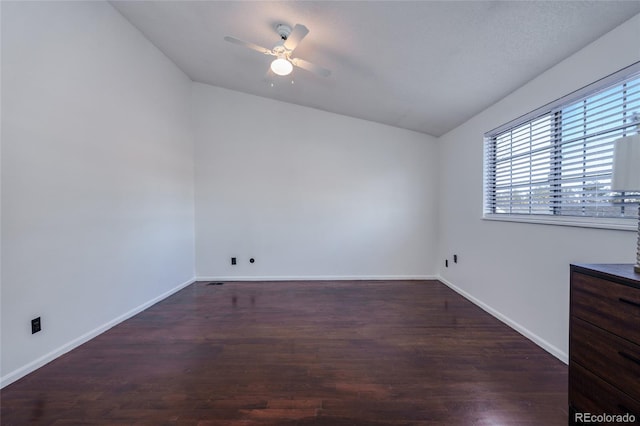 unfurnished room with a ceiling fan, vaulted ceiling, baseboards, and wood finished floors