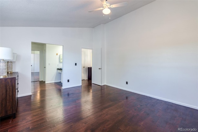 unfurnished bedroom with lofted ceiling, a textured ceiling, baseboards, and dark wood-type flooring