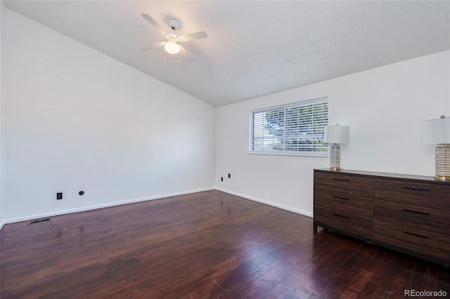 unfurnished bedroom with visible vents, baseboards, ceiling fan, dark wood-type flooring, and vaulted ceiling