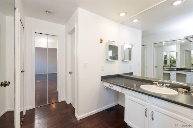 bathroom featuring visible vents, baseboards, wood finished floors, vanity, and recessed lighting