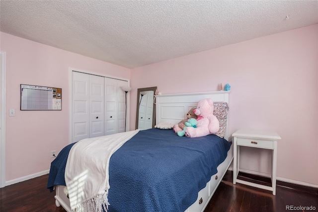 bedroom with a textured ceiling, a closet, baseboards, and wood finished floors